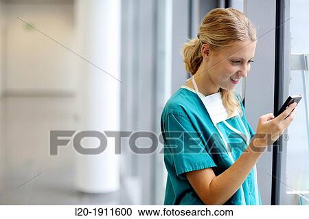 Stock Image - surgeon with smartphone in the operating room hallway, Onkologikoa Hospital, Oncology Institute, Case Center for prevention, diagnosis and treatment of cancer, Donostia, San Sebastian, Gipuzkoa, Basque Country, Spain. Fotosearch