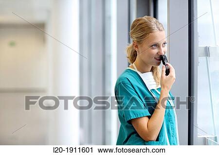 Stock Image - surgeon with smartphone in the operating room hallway, Onkologikoa Hospital, Oncology Institute, Case Center for prevention, diagnosis and treatment of cancer, Donostia, San Sebastian, Gipuzkoa, Basque Country, Spain. Fotosearch