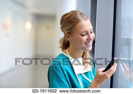 Stock Image - surgeon with smartphone in the operating room hallway, Onkologikoa Hospital, Oncology Institute, Case Center for prevention, diagnosis and treatment of cancer, Donostia, San Sebastian, Gipuzkoa, Basque Country, Spain. Fotosearch