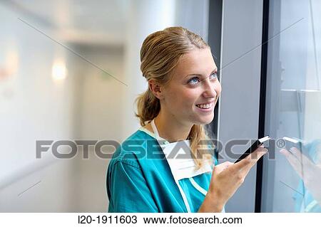 Stock Image - surgeon with smartphone in the operating room hallway, Onkologikoa Hospital, Oncology Institute, Case Center for prevention, diagnosis and treatment of cancer, Donostia, San Sebastian, Gipuzkoa, Basque Country, Spain. Fotosearch