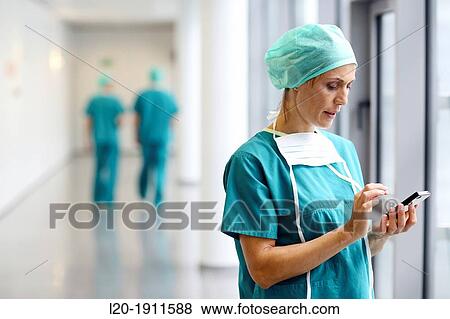 Stock Photo - surgeon with smartphone in the operating room hallway, Onkologikoa Hospital, Oncology Institute, Case Center for prevention, diagnosis and treatment of cancer, Donostia, San Sebastian, Gipuzkoa, Basque Country, Spain. Fotosearch
