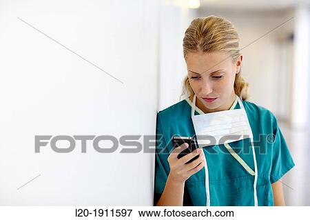 Stock Photo - surgeon with smartphone in the operating room hallway, Onkologikoa Hospital, Oncology Institute, Case Center for prevention, diagnosis and treatment of cancer, Donostia, San Sebastian, Gipuzkoa, Basque Country, Spain. Fotosearch