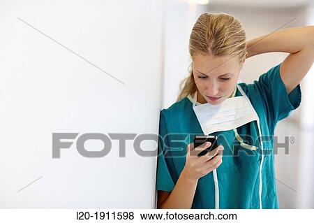Stock Photo - surgeon with smartphone in the operating room hallway, Onkologikoa Hospital, Oncology Institute, Case Center for prevention, diagnosis and treatment of cancer, Donostia, San Sebastian, Gipuzkoa, Basque Country, Spain. Fotosearch