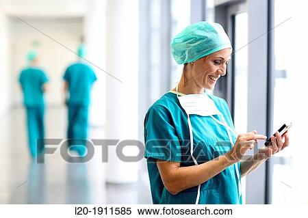 Stock Photography - surgeon with smartphone in the operating room hallway, Onkologikoa Hospital, Oncology Institute, Case Center for prevention, diagnosis and treatment of cancer, Donostia, San Sebastian, Gipuzkoa, Basque Country, Spain. Fotosearch