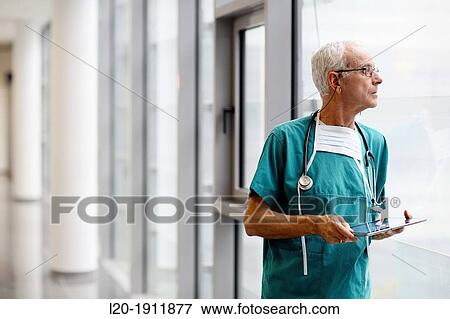 Stock Photo - surgeon with tablet in the operating room hallway, Onkologikoa Hospital, Oncology Institute, Case Center for prevention, diagnosis and treatment of cancer, Donostia, San Sebastian, Gipuzkoa, Basque Country, Spain. Fotosearch