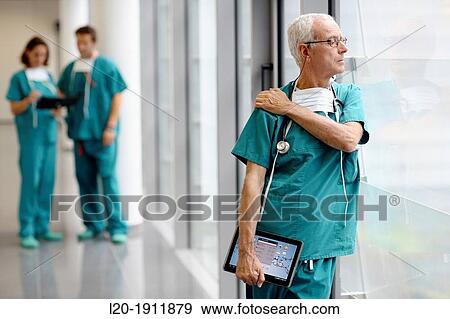 Stock Photo - surgeon with tablet in the operating room hallway, Onkologikoa Hospital, Oncology Institute, Case Center for prevention, diagnosis and treatment of cancer, Donostia, San Sebastian, Gipuzkoa, Basque Country, Spain. Fotosearch