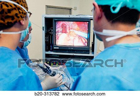 Stock Image - Surgeons at laparoscopy operating room of hospital. Fotosearch