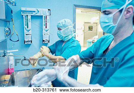 Stock Image - Surgeons washing hands at traumatology operating room of hospital. Fotosearch