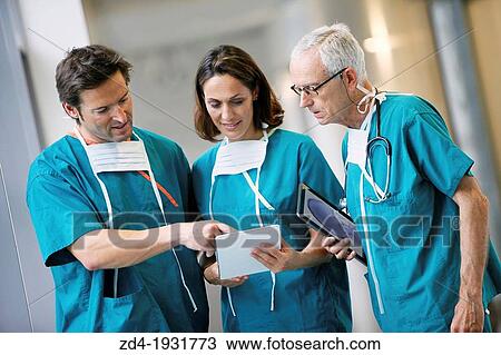 Stock Image - Surgeons with tablet in the operating room hallway, Onkologikoa Hospital, Oncology Institute, Case Center for prevention, diagnosis and treatment of cancer, Donostia, San Sebastian, Gipuzkoa, Basque Country, Spain. Fotosearch