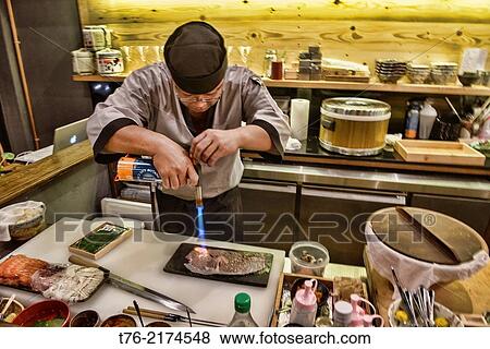sushi chef blowtorching Matsuzaka beef at a Japanese restaurant in Bangkok, Thailand. View Large Photo Image Stock Photo - sushi chef blowtorching Matsuzaka beef at a Japanese restaurant in Bangkok, Thailand.. Fotosearch