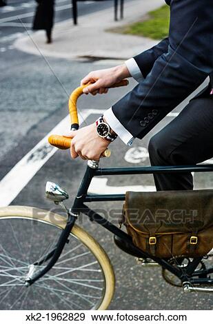 Sustaintable gentleman riding a bike for commuting, London, UK View Large Photo Image Stock Photo - Sustaintable gentleman riding a bike for commuting, London, UK. Fotosearch