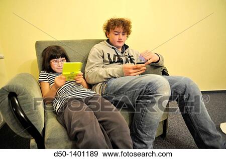 Swedish 10 and 14 year old playing games on their Nintendo and iPhone in hotel, Zakopane, Poland View Large Photo Image Stock Photo - Swedish 10 and 14 year old playing games on their Nintendo and iPhone in hotel, Zakopane, Poland. Fotosearch