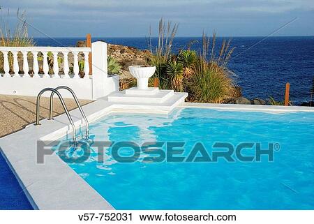 Stock Image - Swimmingpool at the seaside, Lanzarote island, Canary Islands, Spain. Fotosearch
