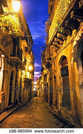 Syracuse Ortygia, Sicily, Italy Lit city street alley at night City has ancient Greek foundations Province of Syracuse View Large Photo Image Picture - Syracuse Ortygia, Sicily, Italy Lit city street alley at night City has ancient Greek foundations Province of Syracuse. Fotosearch