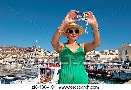 Syros Greece Islands in Hermoupolis capital in marina harbor boats ships port white buildings water boating fishing architecture with tourist lady in green with camera taking pictures View Large Photo Image Stock Image - Syros Greece Islands in Hermoupolis capital in marina harbor boats ships port white buildings water boating fishing architecture with tourist lady in green with camera taking pictures. Fotosearch