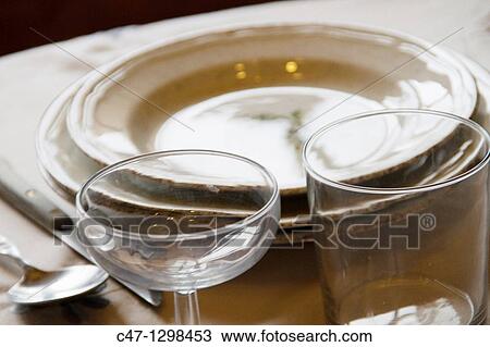 Stock Image - Table set with plates, cups, glasses, cover, tablecloth, spoons, forks and knives. Fotosearch