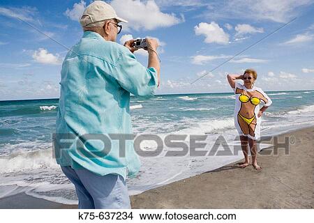 Picture - Taking a photo of wife in a humorous tee-shirt. Fotosearch