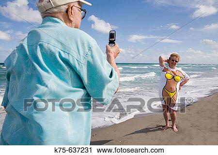 Taking picture of his wife in fun tee-shirt View Large Photo Image Stock Image - Taking picture of his wife in fun tee-shirt. Fotosearch