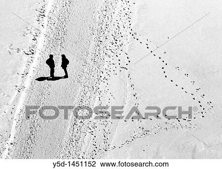 Stock Image - talking couple in high Swiss Alps, Jungfraujoch called Top of Europe, highest point in Europe where you can get by rail, UNESCO heritage. Fotosearch