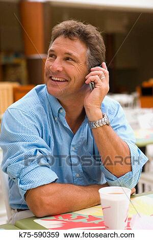 Talking on cell phone at caf? View Large Photo Image Stock Photo - Talking on cell phone at caf?. Fotosearch