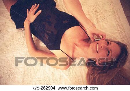 Picture - talking on phone in bed. Fotosearch