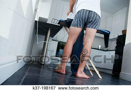 Tattooed man ironing his jeans View Large Photo Image Stock Photo - Tattooed man ironing his jeans. Fotosearch