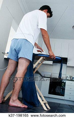 Tattooed man ironing his jeans View Large Photo Image Stock Photography - Tattooed man ironing his jeans. Fotosearch