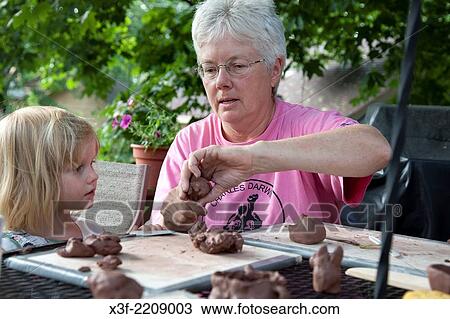 Teacher demonstrating the art of modeling ceramic clay to student age 3 in outdoor backyard class. St Paul Minnesota MN USA. View Large Photo Image Stock Image - Teacher demonstrating the art of modeling ceramic clay to student age 3 in outdoor backyard class. St Paul Minnesota MN USA.. Fotosearch