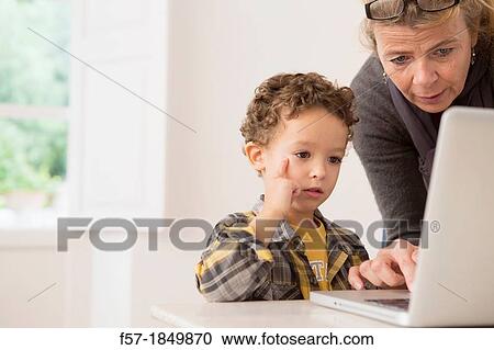 Teacher showing four year old boy how to use a laptop View Large Photo Image Stock Image - Teacher showing four year old boy how to use a laptop. Fotosearch