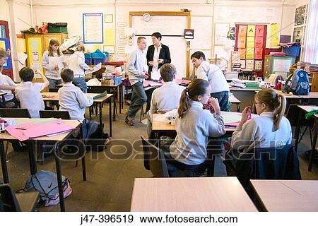 Stock Photo - Teacher teaching a classroom of 12-13 year old children in a comprehensive school, Sheffield. Fotosearch