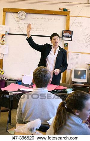 Teacher with one hand in the air, teaching a classroom of 12-13 year old children in a comprehensive school, Sheffield View Large Photo Image Stock Image - Teacher with one hand in the air, teaching a classroom of 12-13 year old children in a comprehensive school, Sheffield. Fotosearch