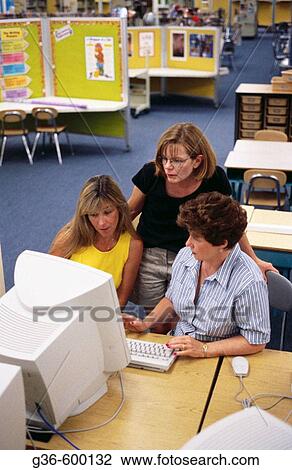 Teachers, looking at computer View Large Photo Image Stock Image - Teachers, looking at computer. Fotosearch