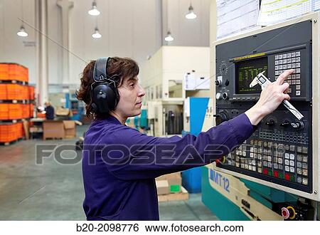 Stock Photograph - Technician CNC control. Area automated CNC lathes. Machined Indecober. Machining of precision parts in series. Automotive industry. Berriz. Bizkaia. Basque Country. Spain.. Fotosearch