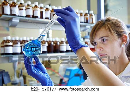 Stock Photo - Technicians get a solutions in flask, Laboratory quality control, Pharmaceutical plant, Research Center, Pharmacy, Area Health, Tecnalia Research & Innovation, Araba Technology Park, Miano, Basque Country, Spain. Fotosearch