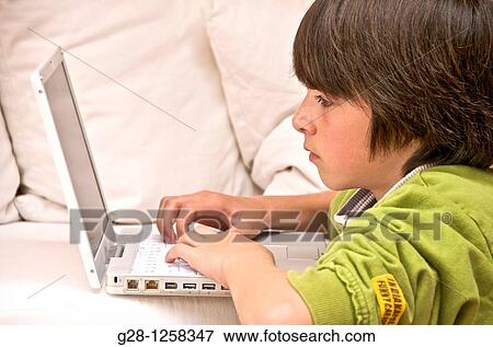 teeanage boy in green sweater, writing and playing on his computer at home View Large Photo Image Stock Photo - teeanage boy in green sweater, writing and playing on his computer at home. Fotosearch