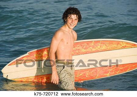 Stock Image - teen and his surfboard. Fotosearch