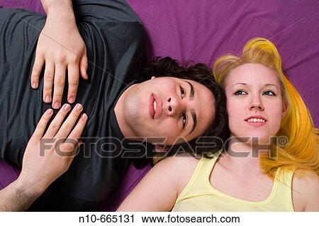 Teen boy and his blond girl friend lying together in bed. View Large Photo Image Stock Image - Teen boy and his blond girl friend lying together in bed.. Fotosearch