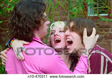 Teen boy holding the heads of a teen girl and a teen boy View Large Photo Image Stock Image - Teen boy holding the heads of a teen girl and a teen boy. Fotosearch