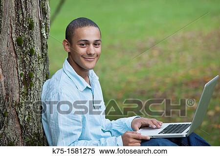 Teen boy studying with laptop View Large Photo Image Stock Photography - Teen boy studying with laptop. Fotosearch