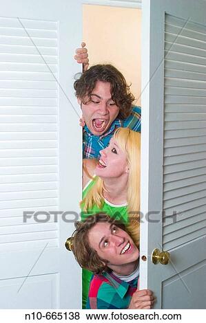 Teen boys and a teen girl sticking their heads out the door from inside a closet. View Large Photo Image Stock Photo - Teen boys and a teen girl sticking their heads out the door from inside a closet.. Fotosearch