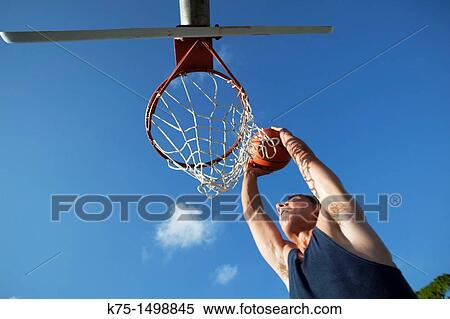 Teen dunking basketball into hoop View Large Photo Image Stock Photography - Teen dunking basketball into hoop. Fotosearch