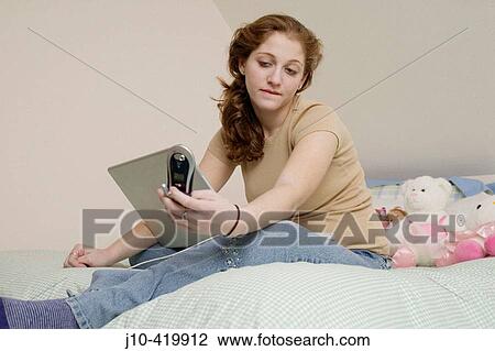 Teen girl age 17 in bedroom, laptop + cell phone, wondering View Large Photo Image Stock Image - Teen girl age 17 in bedroom, laptop + cell phone, wondering. Fotosearch