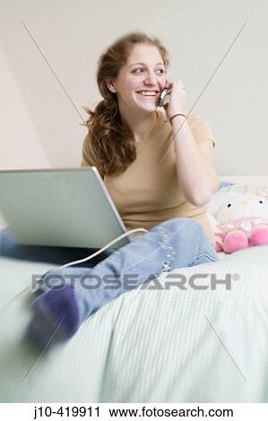 Teen girl age 17 in bedroom with laptop computer and cellphone, lens blur View Large Photo Image Stock Image - Teen girl age 17 in bedroom with laptop computer and cellphone, lens blur. Fotosearch