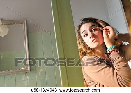 Teen girl applying eyeliner View Large Photo Image Stock Image - Teen girl applying eyeliner. Fotosearch