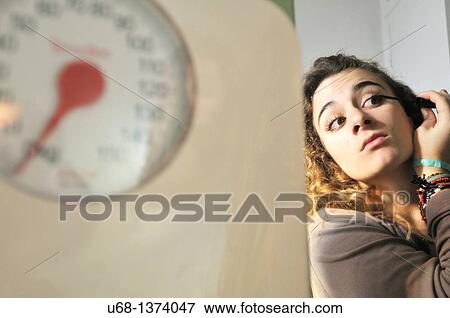 Teen girl applying mascara, bathroom scales View Large Photo Image Stock Photo - Teen girl applying mascara, bathroom scales. Fotosearch