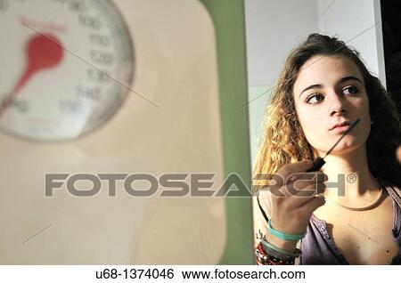 Teen girl applying mascara, bathroom scales View Large Photo Image Stock Photograph - Teen girl applying mascara, bathroom scales. Fotosearch