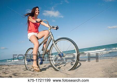 Stock Photo - Teen girl biking at the beach. Fotosearch