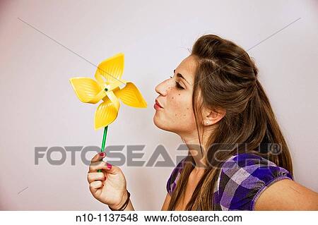 Teen girl blowing on a pinwheel View Large Photo Image Stock Photo - Teen girl blowing on a pinwheel. Fotosearch