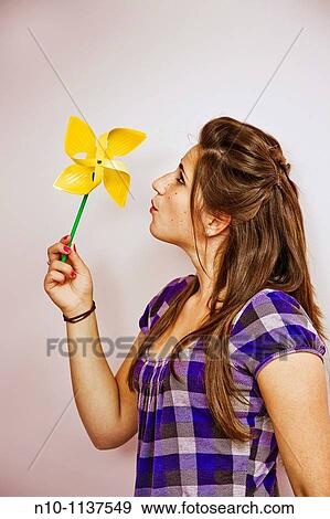 Teen girl blowing on a pinwheel View Large Photo Image Stock Photo - Teen girl blowing on a pinwheel. Fotosearch