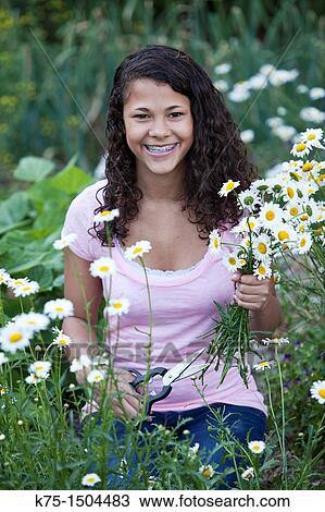 Teen girl cutting a bouquet of daisies View Large Photo Image Stock Image - Teen girl cutting a bouquet of daisies. Fotosearch